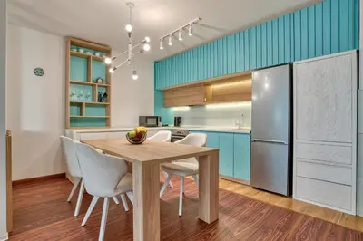 a kitchen with a wooden table and white chairs at Blue Lagoon in Petrovac na Moru