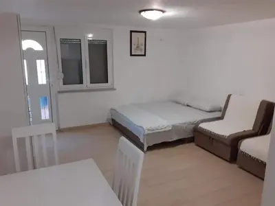 a room with a bed and a couch and a chair at Apartmani Roki in Tivat