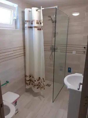 a bathroom with a shower and a toilet and a sink at Apartmani Roki in Tivat