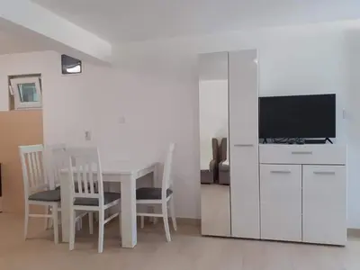 a living room with a table and a tv at Apartmani Roki in Tivat