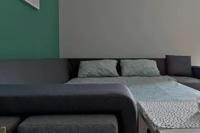 a couch with two pillows and a bench in a room at Studio 357 Cetinje in Cetinje
