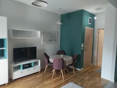 a dining room with a table with chairs and a television at Studio 357 Cetinje in Cetinje