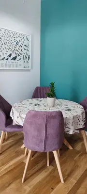 a dining room table with purple chairs and a plant on it at Studio 357 Cetinje in Cetinje
