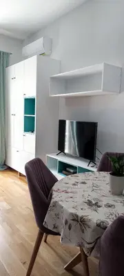 a living room with a table and a tv at Studio 357 Cetinje in Cetinje