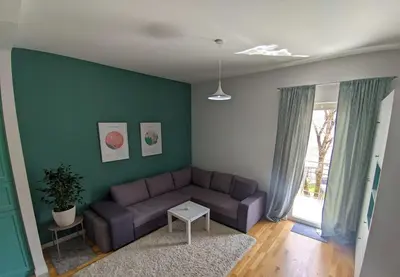 a living room with a couch and a green wall at Studio 357 Cetinje in Cetinje