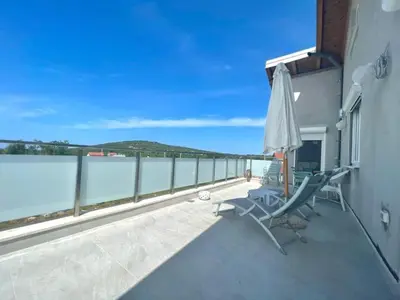 a balcony with an umbrella and chairs and the water at Family Apartments Stefan in Budva