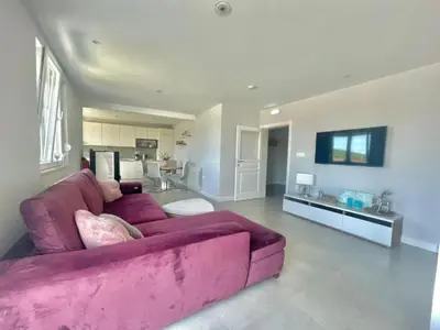 a living room with a purple couch and a kitchen at Family Apartments Stefan in Budva