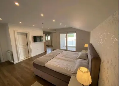 a bedroom with a large bed and a television at Family Apartments Stefan in Budva