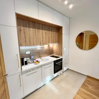 a kitchen with white cabinets and a sink at Apartments Doclea in Podgorica