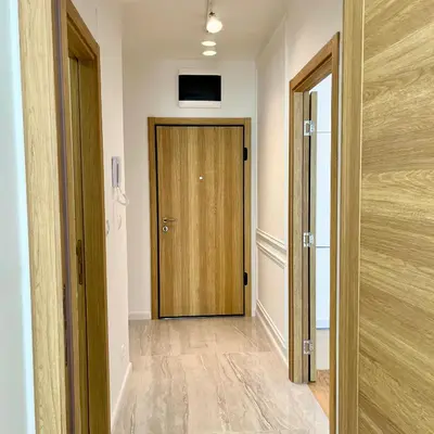 a hallway with a wooden door in a room at Apartments Doclea in Podgorica