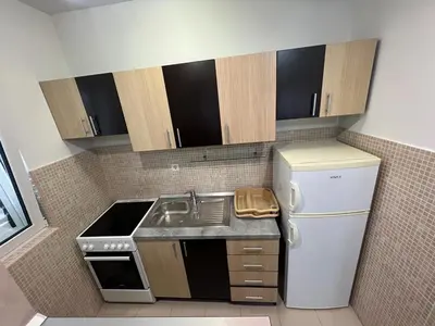 a small kitchen with a sink and a refrigerator at Budva Apartments in Budva