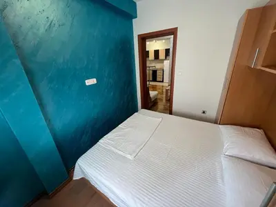 a bed in a room with a blue wall at Budva Apartments in Budva