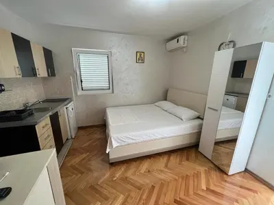 a small room with a bed and a kitchen at Budva Apartments in Budva