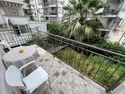 a balcony with a table and chairs and a palm tree at Budva Apartments in Budva