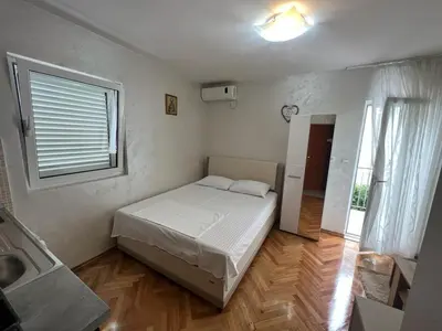 a small bedroom with a bed and a window at Budva Apartments in Budva