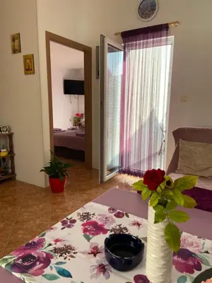 a room with a table with a vase with flowers on it at Apartment Alex in Kotor