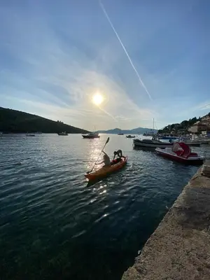 a person in a paddle boat on a lake at Apartment Alex in Kotor