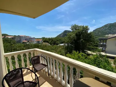 a balcony with a chair and a view of mountains at Romantic auch mit Kindern in Sutomore