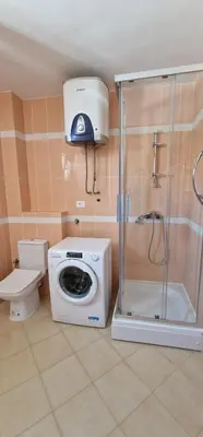 a bathroom with a washing machine and a shower at APARTMANI NINI in Rafailovici