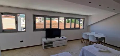 a living room with a tv and a table and chairs at APARTMANI NINI in Rafailovici