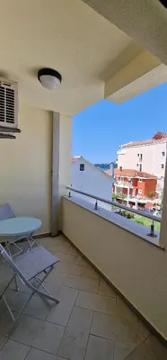 a balcony with a table and a view of a city at APARTMANI NINI in Rafailovici