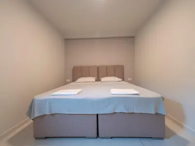 a bedroom with a large bed with two sheets at Seaview Villa with pool-Vanja in Budva