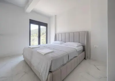 a large bed in a white room with a window at Seaview Villa with pool-Vanja in Budva
