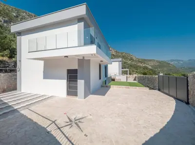 a white house with a blue roof and a patio at Seaview Villa with pool-Vanja in Budva