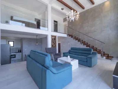 a living room with blue couches and a staircase at Seaview Villa with pool-Vanja in Budva