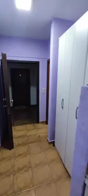 an empty room with purple walls and a hallway with lockers at Sutomore apartman in Sutomore