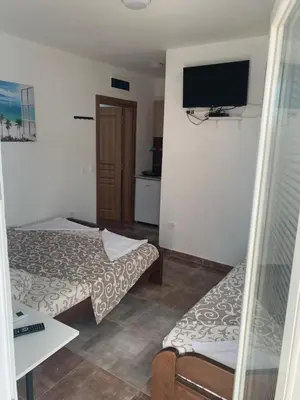 a hotel room with two beds and a flat screen tv at LamijaApartmani 1 in Sutomore