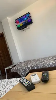 a room with two remote controls and a tv on a couch at LamijaApartmani 1 in Sutomore