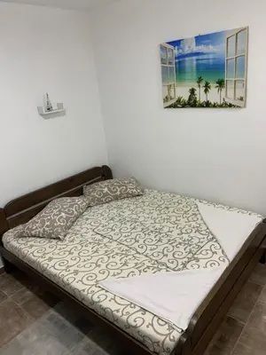 a bed in a room with a picture on the wall at LamijaApartmani 1 in Sutomore