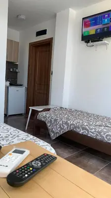 a room with a bed with a remote control on a table at LamijaApartmani 1 in Sutomore