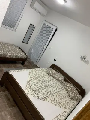 a bedroom with two beds and two windows at LamijaApartmani 1 in Sutomore