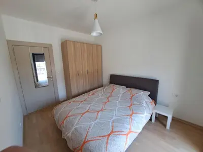 a bedroom with a bed and a window and a door at Home Away Apartment in Podgorica