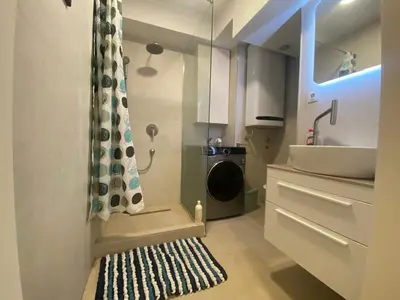 a bathroom with a sink and a washing machine at Podgorica 23 in Podgorica