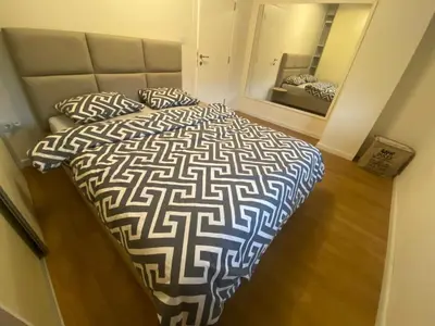 a bedroom with a large bed with pillows and a mirror at Podgorica 23 in Podgorica