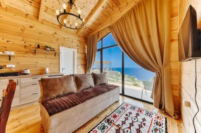 a living room with a couch and a large window at Olive Hills Holiday homes 1 & 2 in Bar