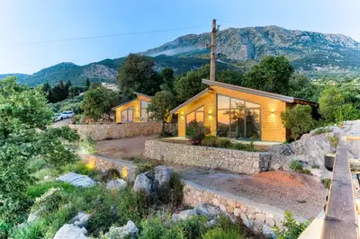 a church on a hill with mountains in the background at Olive Hills Holiday homes 1 & 2 in Bar