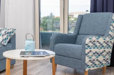 a living room with a chair and a table at La barca apartments in Becici