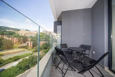 a balcony with chairs and a table and a window at La barca apartments in Becici