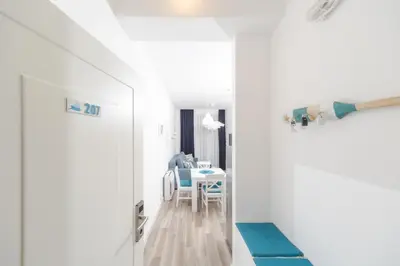 a room with white walls and a table and chairs at La barca apartments in Becici