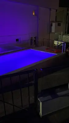 a swimming pool with blue lighting in a building at Emma Lux Apartment in Dobra Voda