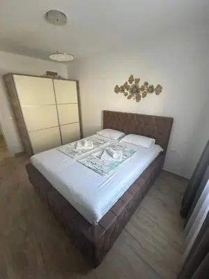 a bedroom with a large bed with white sheets at Emma Lux Apartment in Dobra Voda