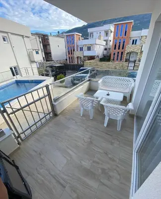 a balcony with a patio furniture and a pool at Emma Lux Apartment in Dobra Voda