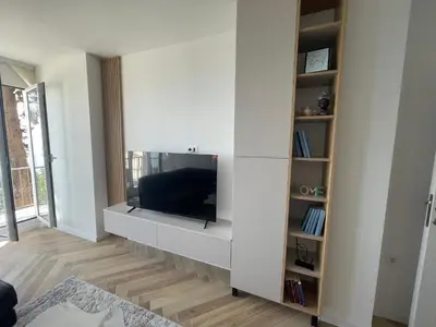 a living room with a tv on a white wall at Pine forest apartment in Ulcinj