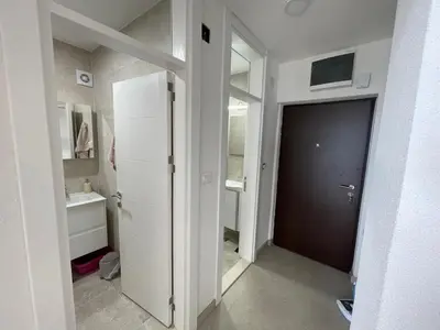 a white hallway with a door and a bathroom at Pine forest apartment in Ulcinj