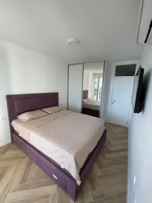 a bedroom with a large bed and a mirror at Pine forest apartment in Ulcinj