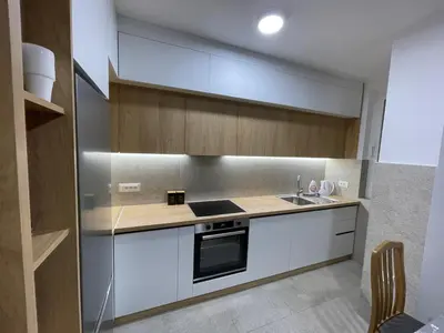 a kitchen with white cabinets and a stove top oven at Pine forest apartment in Ulcinj